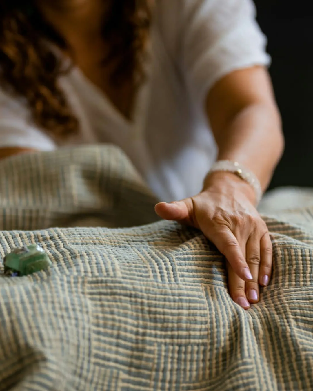 Vanessa's hand resting gently on a draped body during a quiet energy session.