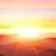 A golden sunrise cresting misty mountain ridges